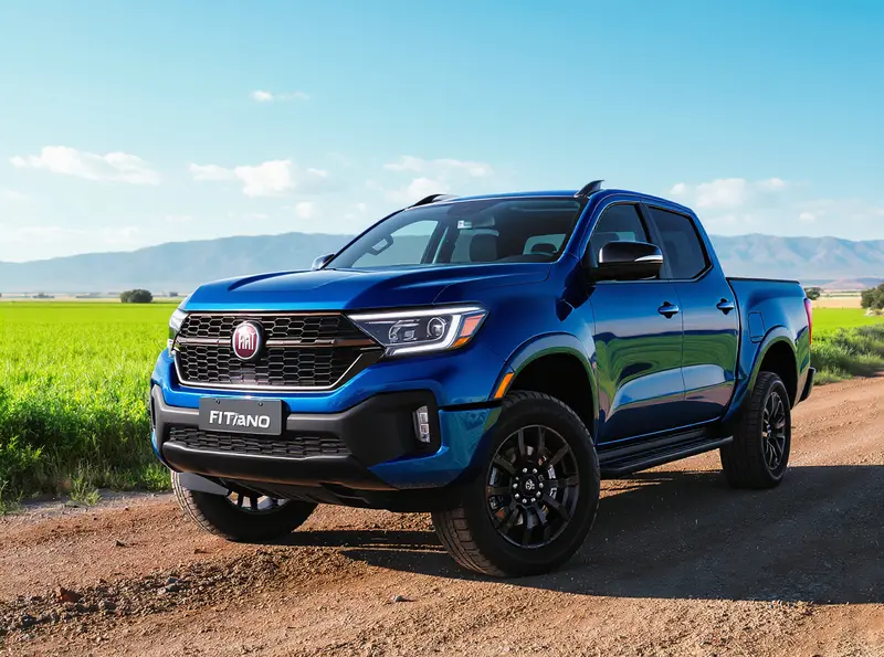 Fiat Titano 2026: Nova Geração Surge com Projeto Inédito Caminhonete Fiat Titano 2026 azul metálico em uma estrada de terra, com montanhas ao fundo.