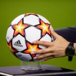 Bola da Champions LEague sendo colocada no pedestal para inicio do jogo