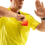 Arbitro de futebol retirando o cartão vermelho do bolso