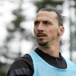 Jogador de futebol Zlatan Ibrahimovic, de cabelo preto e colete azul durante treino.
