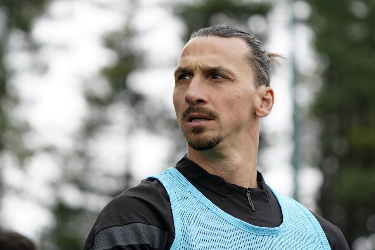 Jogador de futebol Zlatan Ibrahimovic, de cabelo preto e colete azul durante treino.