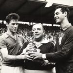 Bellini, Vicente Feola e Gylmar seguram a taça da Copa do Mundo de 1958, em preto e branco.