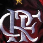 Escudo do Flamengo bordado em sua camisa vermelha e preta, visto bem de perto.
