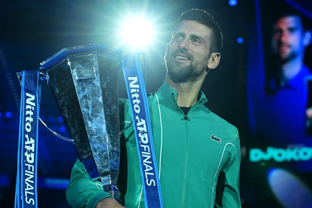 Novak Djokovic, vestindo camisa verde, em premiação ao receber o troféu do ATP Finals 2023