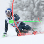 Lucas Pinheiro Braathen esquiando em alta velocidade em uma pista de esqui alpino nevada.