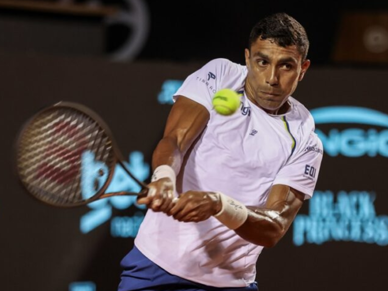 Alexander Zverev e Thiago Monteiro jogando tênis durante o Rio Open, com torcida ao fundo.
