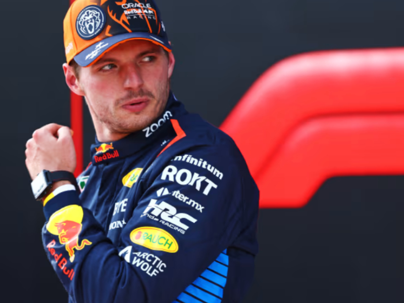 Adrian Newey explicando detalhes técnicos para Max Verstappen durante um GP de Fórmula 1.