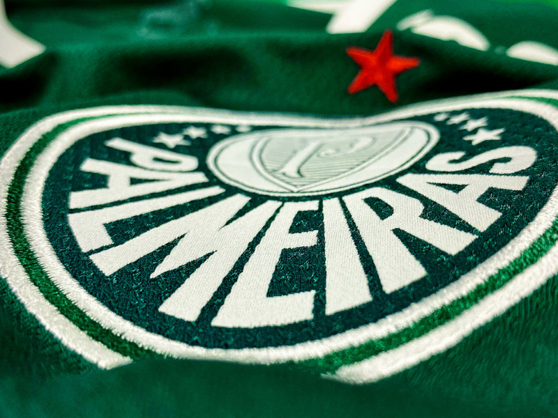 Raphael Veiga comemora gol da vitória do Palmeiras no Campeonato Paulista, torcida ao fundo.