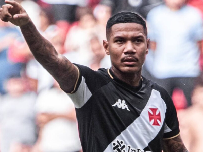 Estádio lotado com torcida do Vasco, jogador comemorando gol.