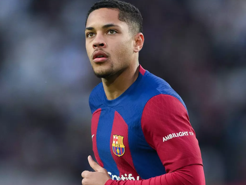 Estádio de futebol lotado com torcedores e bola em movimento.