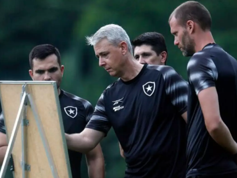 Jogador do Botafogo dominando a bola em um estádio vibrante com torcedores apaixonados.