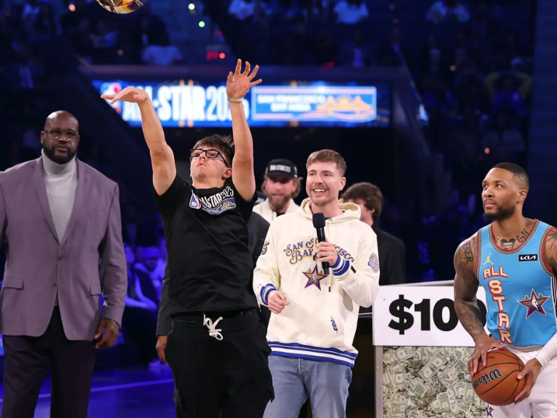 Jovem jogador de basquete comemorando vitória sobre Damian Lillard em competição, com balões e confetes ao fundo.