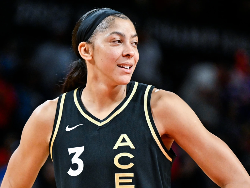 Candace Parker sorrindo no banco de reservas do NBA All-Star Game.