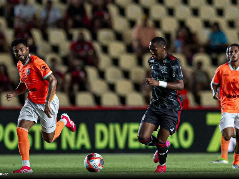 Mesa de negociação vazia com documentos e laptop exibindo gráfico em queda.