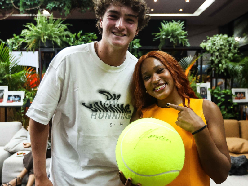 Rebeca Andrade pedindo autógrafo a João Fonseca em ambiente esportivo.