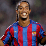 Ronaldinho Gaúcho sorrindo e driblando a bola em um jogo noturno pelo Barcelona.