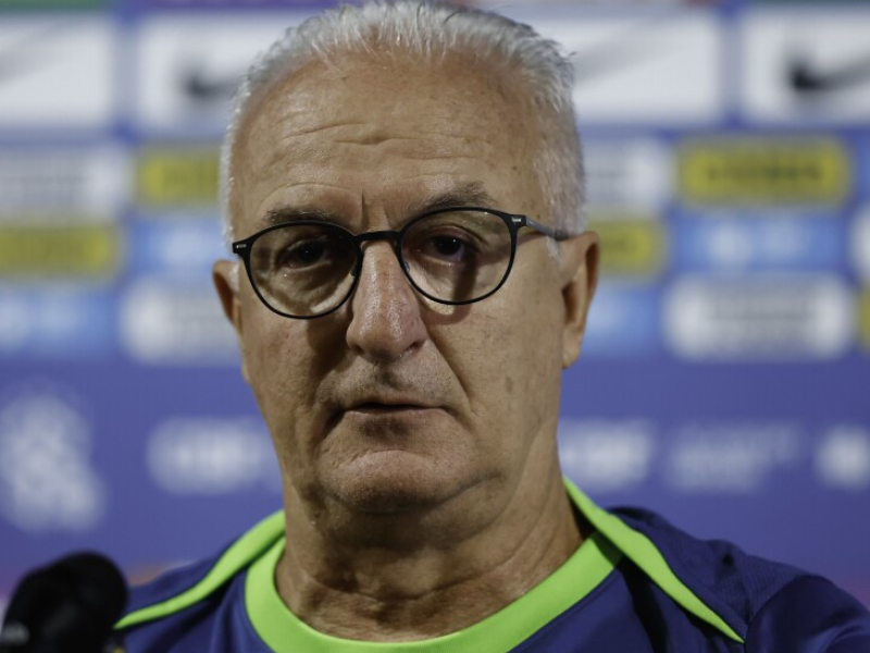 Imagem de close-up de Dorival Júnior refletindo em seu escritório.