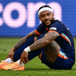 Memphis Depay sorrindo e segurando placa comemorativa da seleção holandesa.