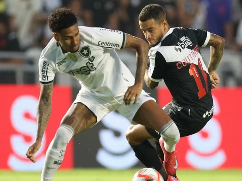 Jogadores de Botafogo e Vasco disputam a bola em um treino de futebol sob a luz do entardecer no Rio de Janeiro.