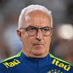 Dorival Júnior gesticulando durante treino da seleção brasileira em estádio lotado.