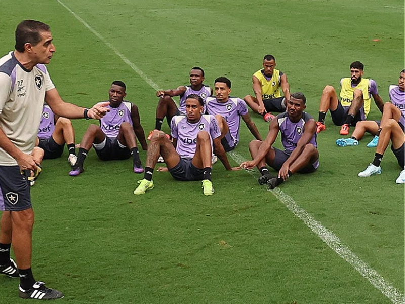 Jogadores do Botafogo treinando intensamente sob a supervisão do técnico Artur Jorge.
