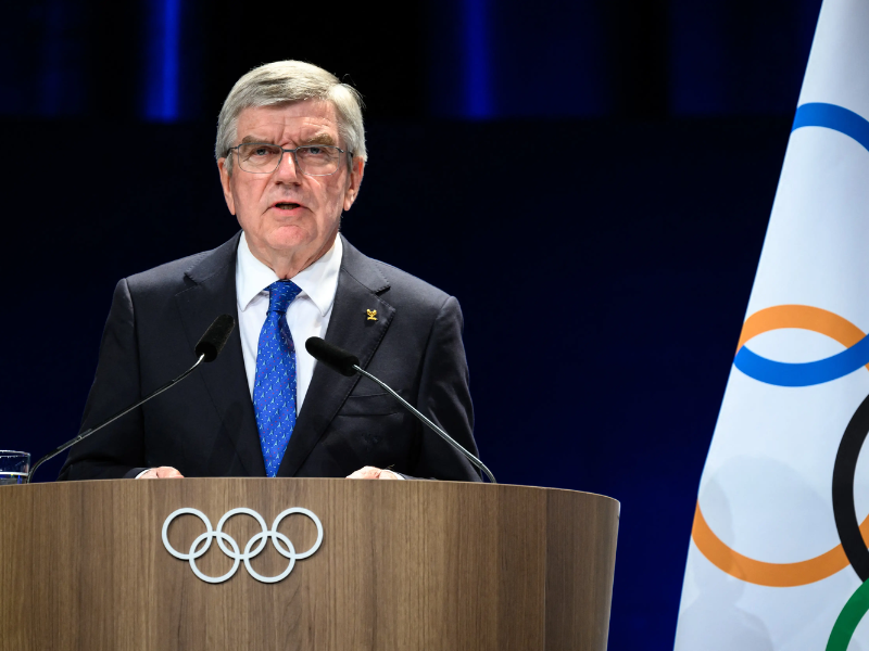 Retrato de Thomas Bach, ex-presidente do COI, em um momento de reflexão e satisfação.