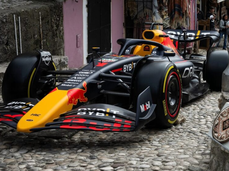 Max Verstappen olhando preocupado para seu carro RB20 nos boxes da Red Bull.