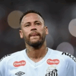 Neymar cabisbaixo em campo chuvoso, representando frustração com lesões.