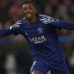 Jogadores do PSG e Arsenal disputando a bola durante um jogo acirrado da Liga dos Campeões.