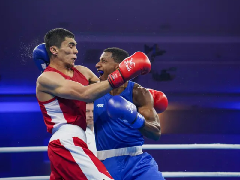 Wanderson 'Shuga' Oliveira comemora vitória na Copa do Mundo de Boxe com a bandeira do Brasil.
