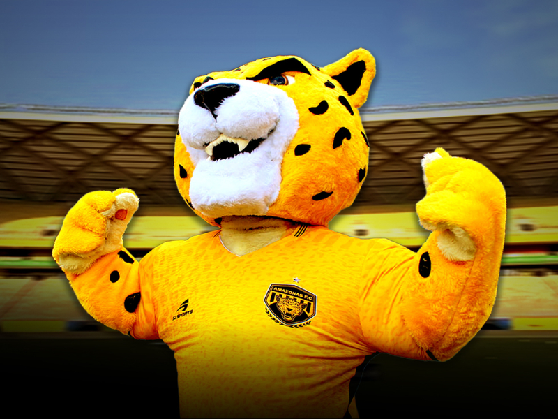 Jogadores do 'Jovem Onça' celebrando um gol em campo na Amazônia, sob o olhar vibrante da torcida.