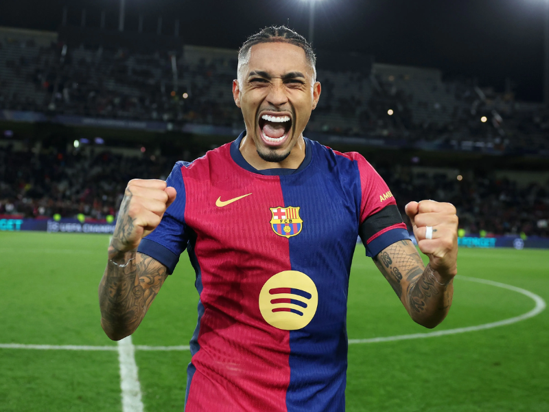 Raphinha driblando durante jogo da Champions League pelo Barcelona.