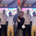 Son Heung-min erguendo a taça da UEFA Europa League com a torcida do Tottenham ao fundo.