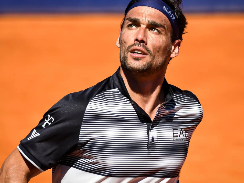 Close-up ultrarrealista de Fábio Fognini na quadra de tênis de Wimbledon, com expressão pensativa e cansada após um jogo.