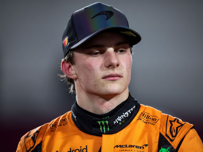 Oscar Piastri, piloto de F1, em close-up no cockpit após a corrida, com expressão pensativa e cansada. Fotografia ultrarrealista.