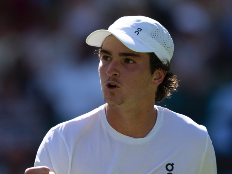 Fotografia ultrarrealista de João Fonseca, tenista brasileiro, realizando um forehand intenso em quadra de grama.