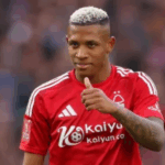 Imagem ultrarrealista de Danilo, jogador de futebol do Botafogo, sorrindo e caminhando em um campo de futebol, com o uniforme do clube e número 22.