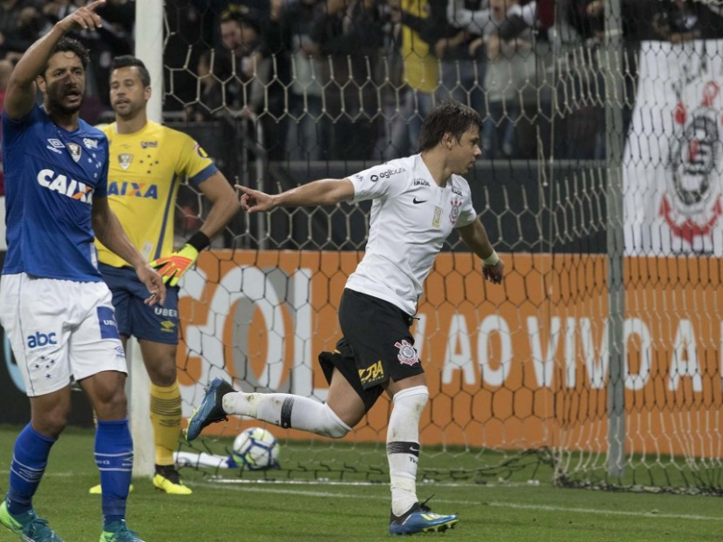 Close-up ultrarrealista de Ángel Romero em campo, chutando uma bola, com uma expressão determinada e uniforme do Corinthians.