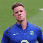 Marc-André ter Stegen, goleiro do Barcelona, sentado em um banco de fisioterapia, com expressão séria mas determinada, indicando sua recuperação após cirurgia.