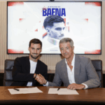 Jogador de futebol não-identificado em uniforme do Atlético de Madrid, de costas, celebrando em campo de futebol.