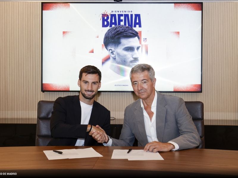Jogador de futebol não-identificado em uniforme do Atlético de Madrid, de costas, celebrando em campo de futebol.