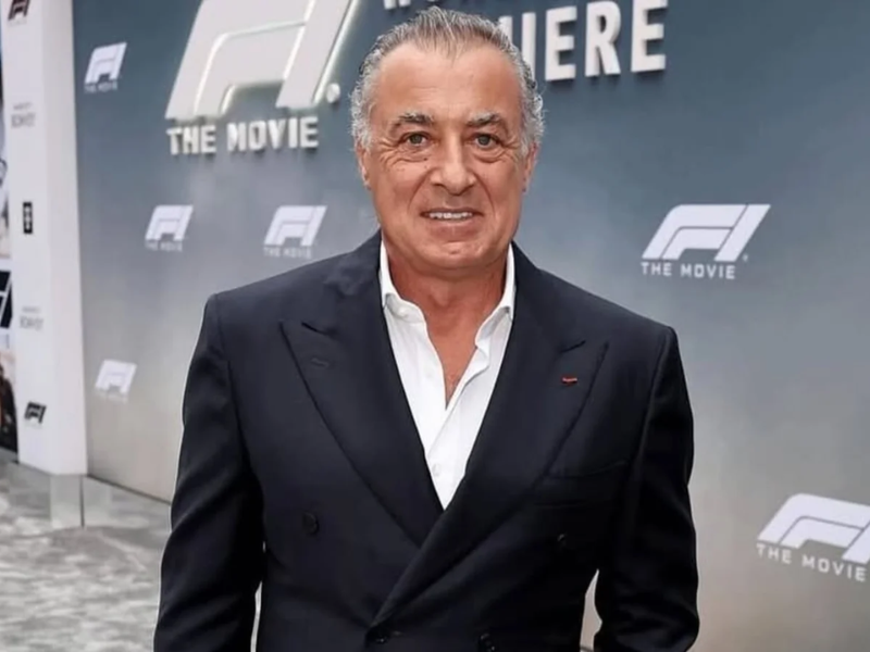 Jean Alesi, ex-piloto, em um estúdio de TV, com expressão séria, fazendo uma crítica à postura de Lewis Hamilton. Imagem noturna.