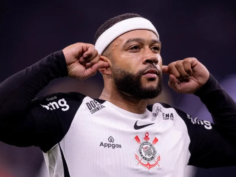 Memphis Depay, com uniforme do Corinthians, pensativo em campo vazio da Neo Química Arena.