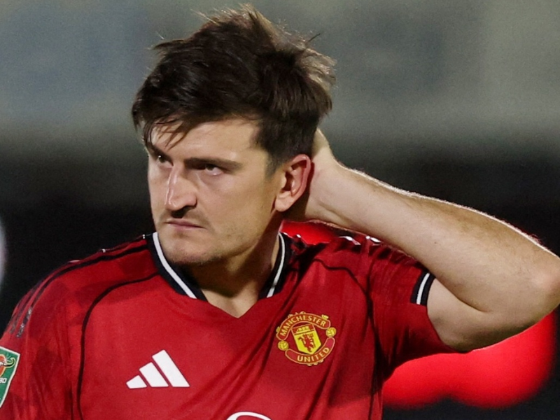 Multidão de torcedores do Grimsby Town em preto e branco invadindo o gramado verde de um estádio de futebol à noite, celebrando.