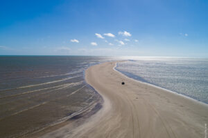 Fenômeno natural impressiona turistas no litoral norte da Paraíba com faixa de areia que surge no mar
